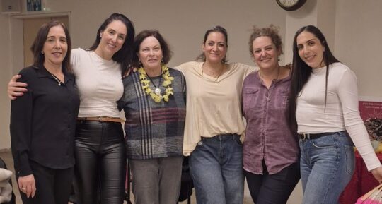 קבוצת נשים מצטלמת יחד בסוף ערב נשים