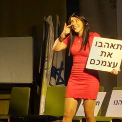 הילה עשור עם שלט "תאהבו את עצמכם"