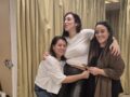 שלוש נשים מתחבקות וצוחקות בערב נשים