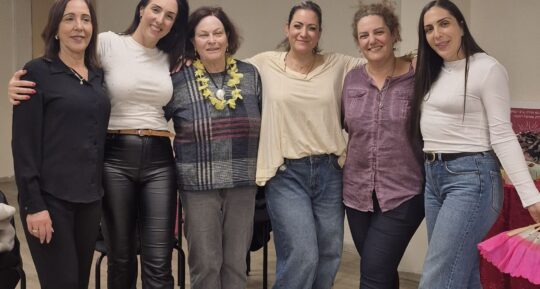 קבוצת נשים מצטלמת בשורה בסוף ערב נשים