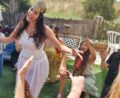כלה עם כתר רוקדת בגינה והחברות מריעות לה
