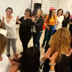 נשים צוחקות ומוחאות כפיים במעגל בערב נשים
